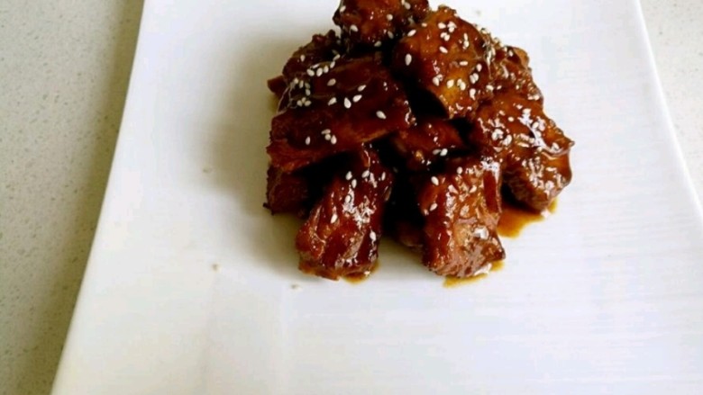 红烧排骨,装入盘中,倒入汤汁,洒入<a style='color:red;display:inline-block;' href='/shicai/ 141765'>熟芝麻</a>,一到美味的红烧排骨就做好了。