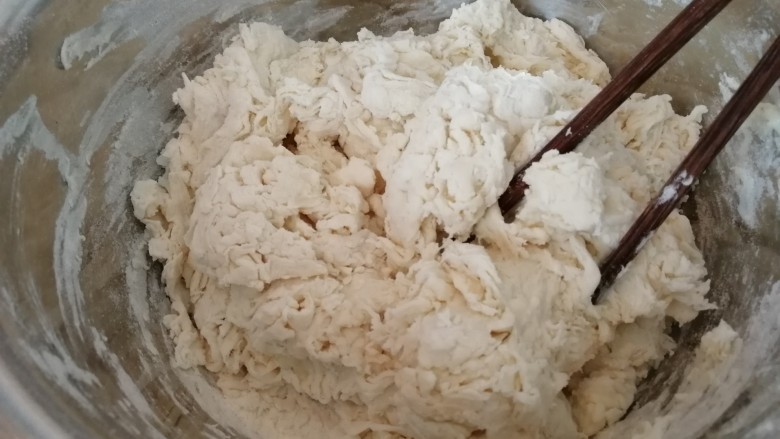 香葱猪肉烧饼,加温水和面,边和边搅拌,搅拌到图片这样就可以了。和烙饼的面一定要软,这样烙出来的饼才会柔软有弹性。