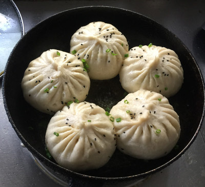 生煎槐花包子,淋食用油,撒黑芝麻、葱花