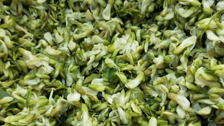 香煎牛肉槐花锅贴,开水锅中放适量盐,倒入槐花焯烫一下,捞出,取适量放凉挤干水分放大碗中。
