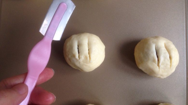 红豆馅司康饼,收口朝下,用割刀划出两条口子。