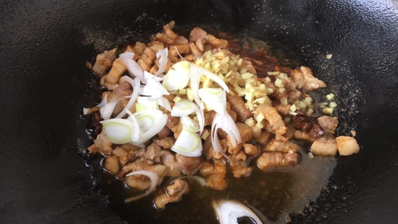#菌类料理# 黑木耳肉丁蚕豆酥,放入葱花和姜末,再次翻炒均匀。