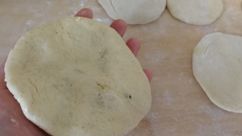 豆粉面地瓜馅饼,手里抹油,把饼慢慢地按薄(如图)