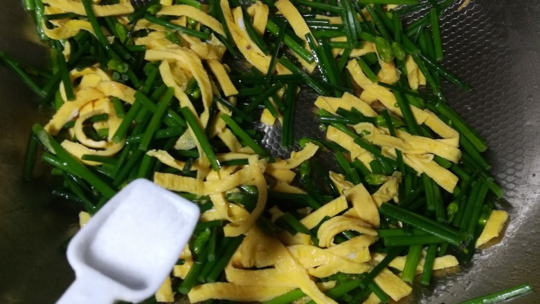 韭苔炒鸡蛋,加入一小勺盐调味,翻匀出锅装盘。尽量大火速炒,保持菜品的清脆的口感和翠绿的颜色。