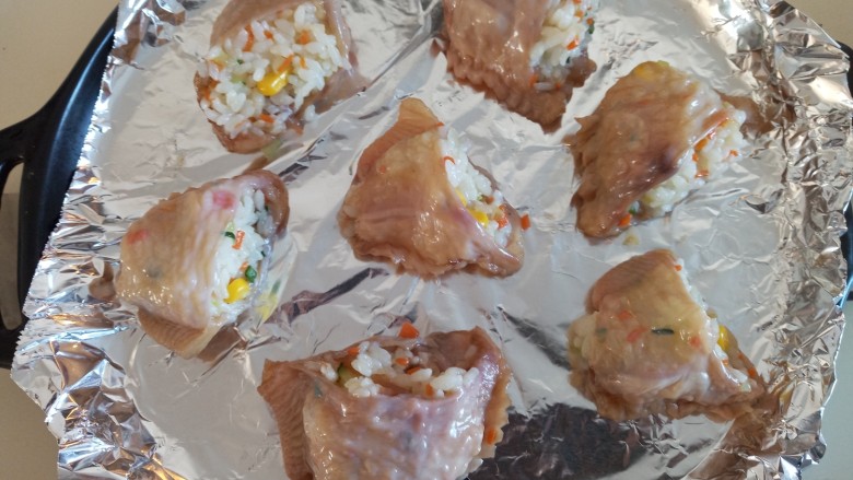 辅食:迷你鸡翅中包米饭,烤盘铺上锡纸,把炒好的米饭塞进鸡翅中放到烤盘上