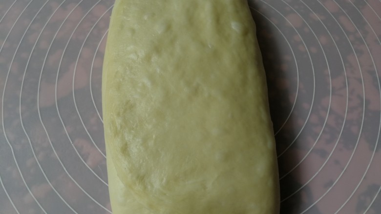 手撕椰蓉面包,将未铺椰蓉馅的1/3部分向中间折叠,然后右侧1/3再向内折叠盖上,呈三层面团两层馅料的状态