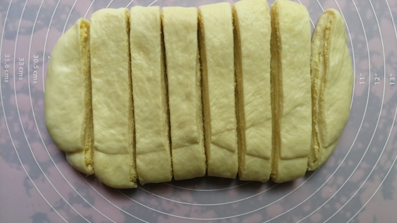 手撕椰蓉面包,二次三折后,再次擀开成长方形,用刀分割成均匀的八份