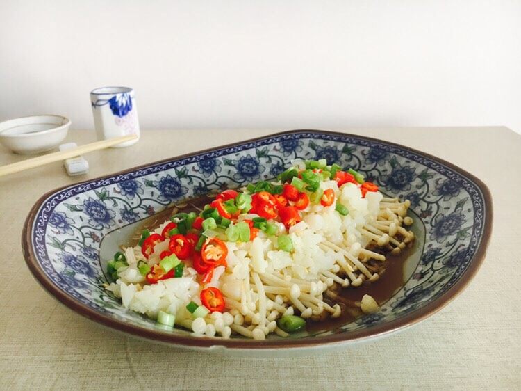 #菌类料理# 蒜蓉辣椒蒸金针菇,从蒸锅里拿出蒸盘,将步骤3的蒜油加热至八成热后,淋入盘中,浇在小米椒上即可。还可以撒些小香葱。
