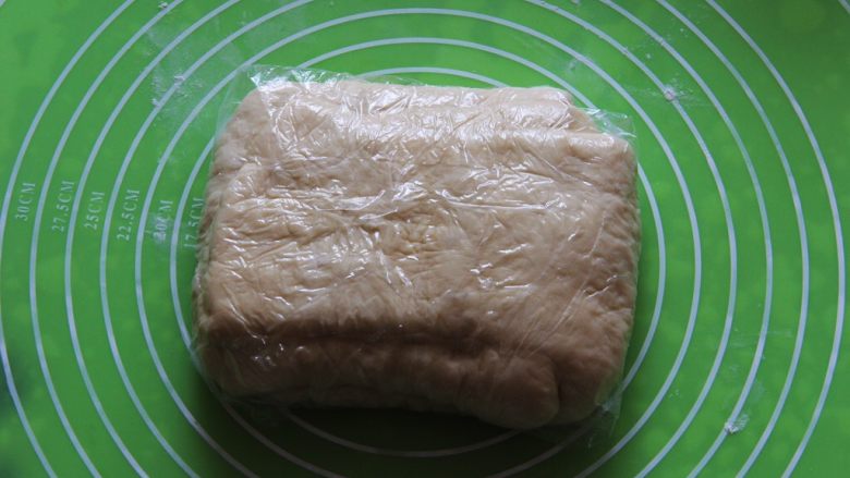 黄油牛角包,包裹保鲜膜,放冰箱冷冻30分钟。