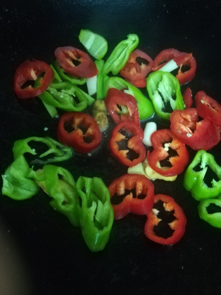 韭菜炒猪肝,起油锅,放入葱姜蒜,青椒,红椒翻炒。