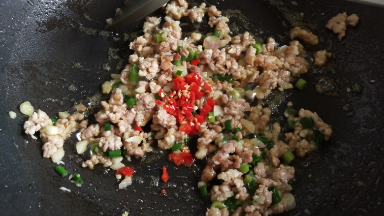 肉沫蒸蓑茄,下蒜泥炒出香味,再放葱花和小辣椒,翻炒几下。