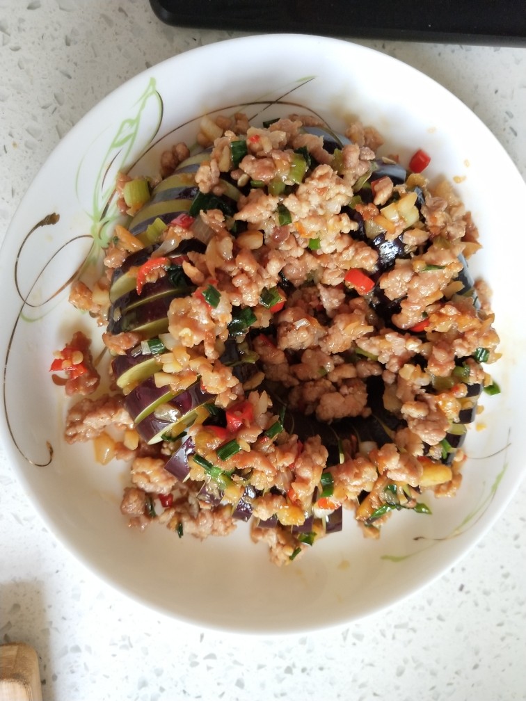 肉沫蒸蓑茄,把炒好的肉沫均匀摆在茄子上,上蒸锅大火蒸8分钟左右即可。