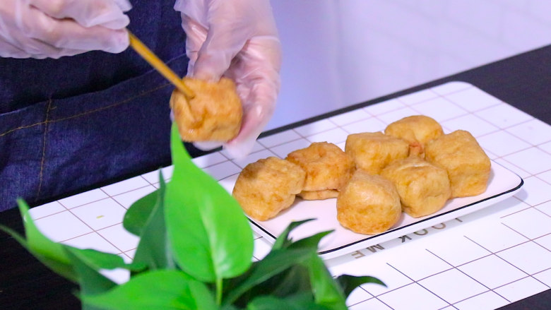 油豆腐塞肉,用筷子在油豆腐上戳一个小孔,并把油豆腐内部掏空