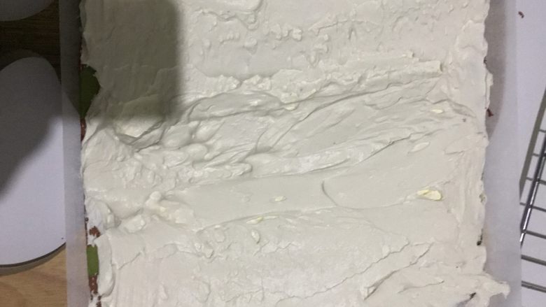 双色蛋糕卷,13.250克淡奶油加入20白糖,用电动打蛋器打至七分状态就可以了。
14.把晾凉的蛋糕片翻过来,底下放上一张油纸,把淡奶油抹在蛋糕片上,中间厚两边薄的状态。