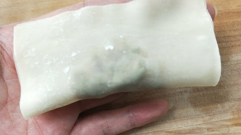 香煎槐花牛肉馄饨,馄饨皮上方用手指抹上一点水,对折捏紧。