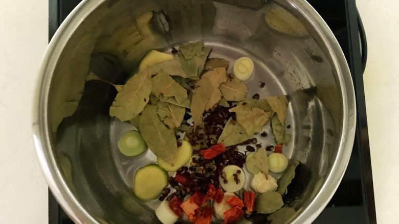 红烧羊肉,炖锅烧热后加入1小勺大豆色拉油,油烧热后加入姜片和葱段,香叶和花椒粒炒出香味