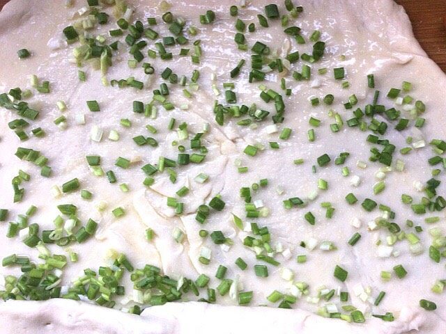 烫面葱花饼,在擀好刷油,撒上少许盐,和葱花,卷起