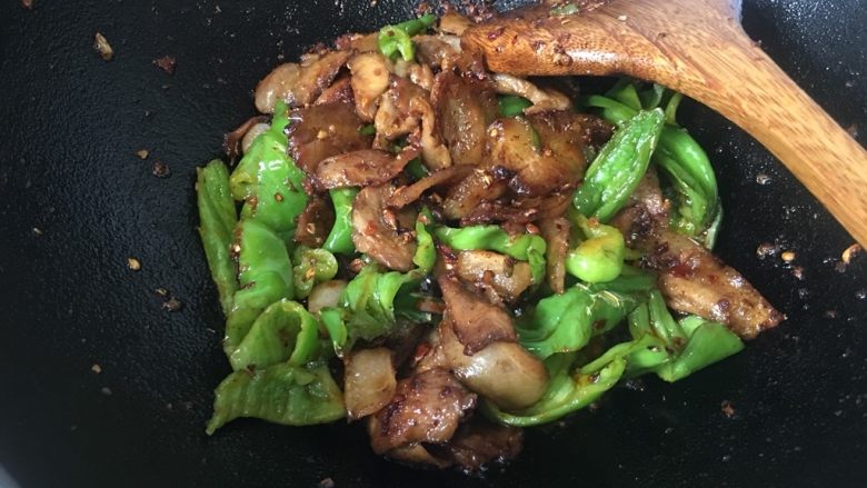 回锅肉,青椒放在肉片下焖10秒左右,让青椒入味、炒熟。
