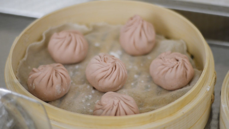 粉嫩豆沙包,包成小包子。发酵半小时。架在散发蒸汽,不烫手的热水上发酵,保持湿度。发酵湿度不够,面皮就会龟裂,蒸出来就坑坑洼洼。