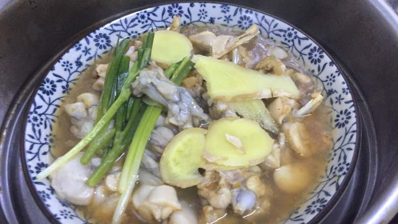 古法蒸牛蛙,水开后蒸5分钟后关火,倒去汤水,去葱姜。