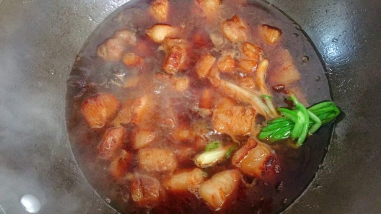 红烧肉炖土豆,添入适量开水,盖上锅盖,中小火炖煮约半小时