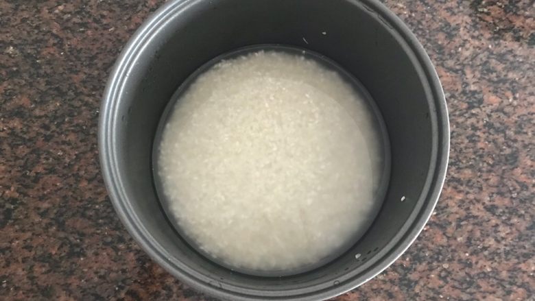 油泼饭捂茄子拌木耳,首先我们先准备好电饭煲要煮的米饭,大米淘洗干净入适量清水(和平时煮饭是一样样的)