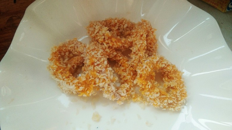 砂锅版黄金鱿鱼圈,外酥里嫩,酸甜可口。,裹好的鱿鱼圈,放入盘子里备用。