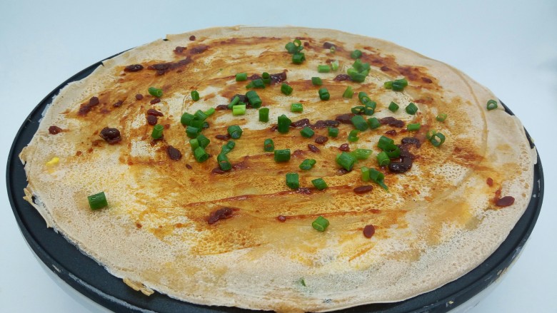 煎饼果子,看煎饼的四周翘起,用木铲子给翻面,不翻也可以,我是为了拍照更加好看,让鸡蛋这一面朝外,刷<a style='color:red;display:inline-block;' href='/shicai/ 4510'>黄豆酱</a>少许,咸淡自己掌握