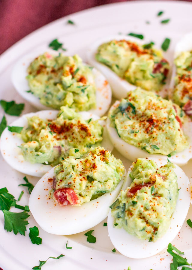 恶魔蛋(Deviled Egg)最美味的7种做法!,<a style='color:red;display:inline-block;' href='/shicai/ 2157'>牛油果</a>番茄香菜恶魔蛋
食材:
6个鸡蛋煮熟去皮,1个中等大小的<a style='color:red;display:inline-block;' href='/shicai/ 2157'>牛油果</a>,2至3茶匙鲜榨酸橙汁,1茶匙红洋葱切碎碎,1茶匙切碎的辣椒,1汤匙切碎的香菜,1汤匙切碎的番茄,适量红辣椒粉用以装饰。
做法:
鸡蛋对切后,只留4个蛋黄与<a style='color:red;display:inline-block;' href='/shicai/ 2157'>牛油果</a>捣碎成泥,加入柠檬汁、红洋葱、辣椒与香菜,盐与胡椒粉。以上充分调味后轻轻拌入番茄碎,就可以用果酱勺舀进蛋白里,最后撒上一点点红辣椒粉,就可以装盘啦!冷藏风味更佳~