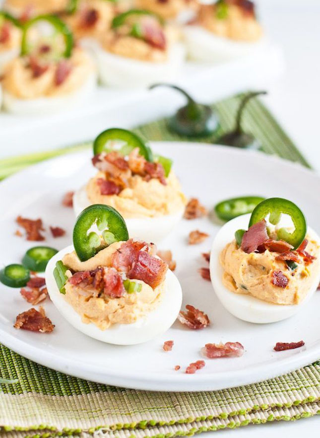 恶魔蛋(Deviled Egg)最美味的7种做法!,<a style='color:red;display:inline-block;' href='/shicai/ 443'>培根</a>辣椒圈恶魔蛋
食材:
12个煮熟的鸡蛋去壳,⅓杯沙拉酱,大约56克软化的奶油芝士,1汤匙醋,1茶匙红糖,3个辣椒,2个切碎的绿色洋葱,6片<a style='color:red;display:inline-block;' href='/shicai/ 443'>培根</a>煮熟弄碎。盐和胡椒粉酌量。
做法:
鸡蛋对半切取蛋黄,辣椒切成丁,与蛋黄、沙拉酱、芝士、充分搅拌,加入醋与红糖,盐与胡椒粉调味。拌匀后用勺子舀进蛋白,把剩下的两个辣椒切成辣椒圈,连同弄碎的<a style='color:red;display:inline-block;' href='/shicai/ 443'>培根</a>放在上面装点。