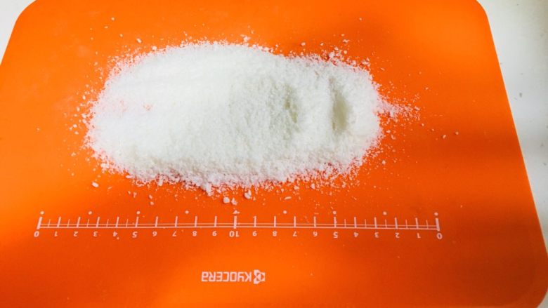 零失败火龙果椰蓉奶冻,这里是第二天的早上了,在菜板上放椰蓉(目的是为了不粘)用刀在容器的周围划一圈,就可以脱模啦