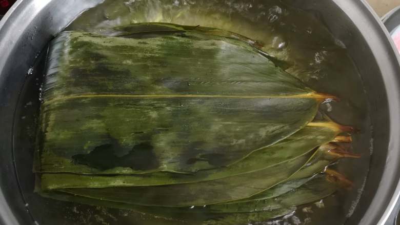 咸蛋猪肉粽,煮十分钟左右即可,然后粽子叶去头去尾后
