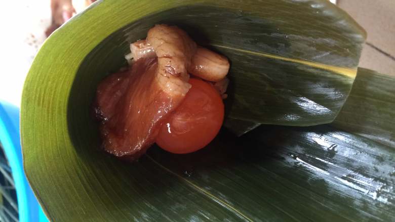 咸蛋猪肉粽,接着放入一颗<a style='color:red;display:inline-block;' href='/shicai/ 13'>咸鸭蛋</a>黄,这里给个特写镜头( ͡° ͜ʖ ͡°)✧