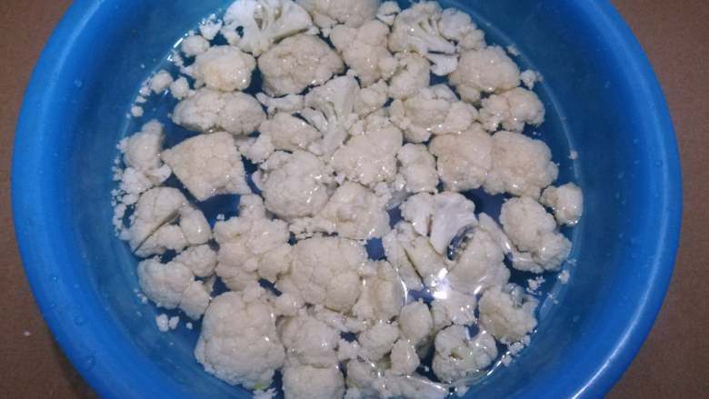 菜花炒腊肉,这时可以处理菜花,切小块泡盐水