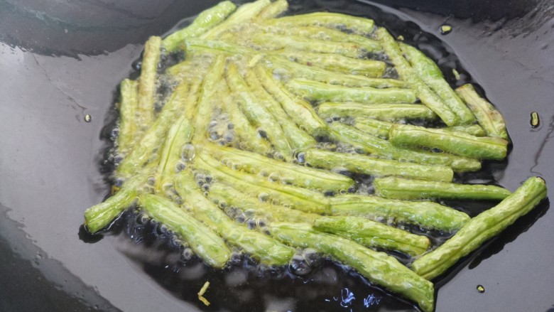 凉拌蒜蓉豇豆,炸至出褶皱,有点变成黄色,即可捞出