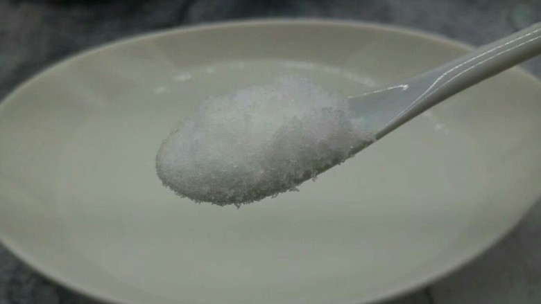 自制菠萝罐头,准备一个大碗,加一勺盐,用筷子把盐搅拌融化