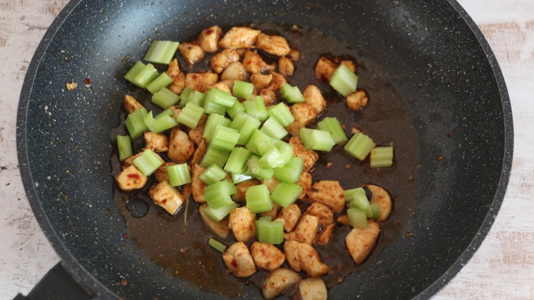 香辣鸡丁,翻炒至鸡肉入味后,加入芹菜丁翻炒。