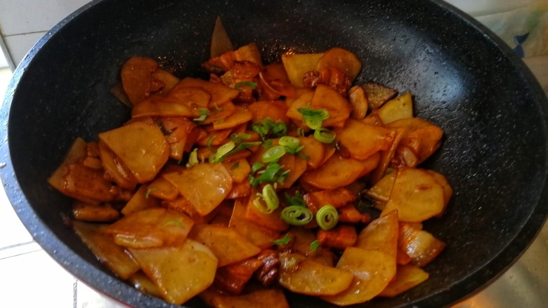 回锅肉香辣土豆片,加点葱碎出锅。