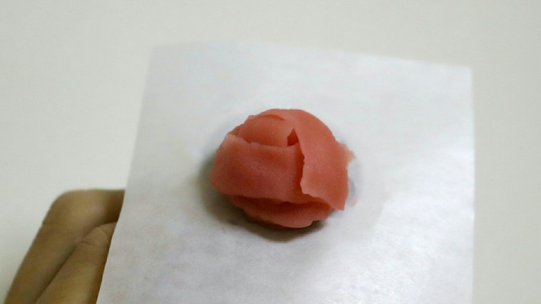 韩式裱花蔓越莓烟囱包,然后裱花心,直接转一圈裱花钉,然后再裱第一层花瓣,共三片。一边挤花瓣一边转动裱花钉。花嘴细头冲上,粗头朝下。