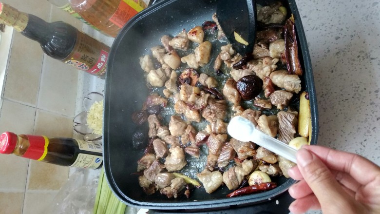 酱香焖牛肉,变色后改成中火,加入盐,翻炒均匀。