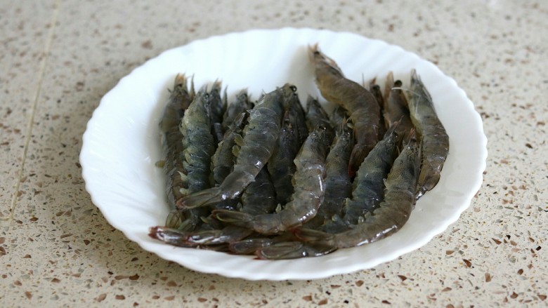 蒜蓉金针菇烤花蛤虾,<a style='color:red;display:inline-block;' href='/shicai/ 291'>明虾</a>洗净剪去虾须虾脚,背后剪开挑去沙线,在腹部剪两刀可以防止烤的时候弯曲起来