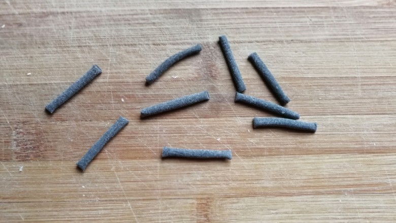 熊猫豆沙馒头,最后取一点小面团搓成细长条,分成均匀的八段,这些小条要用来做熊猫的嘴巴