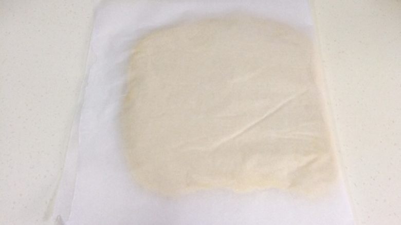 蔓越莓方块小面包,用油纸包好面片,放入冰箱冷冻松弛20分。(冷冻是为了后面好整形,冻到面团变硬但是可以擀开的程度,具体时间长短会受由面团厚度和冰箱温度来决定)
