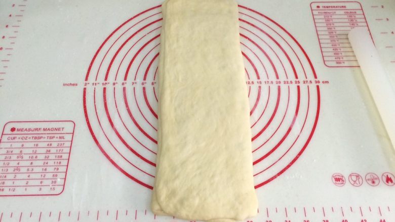 蔓越莓方块小面包,上下两侧分别向中间1/3处折叠,顺着上下方向擀长。