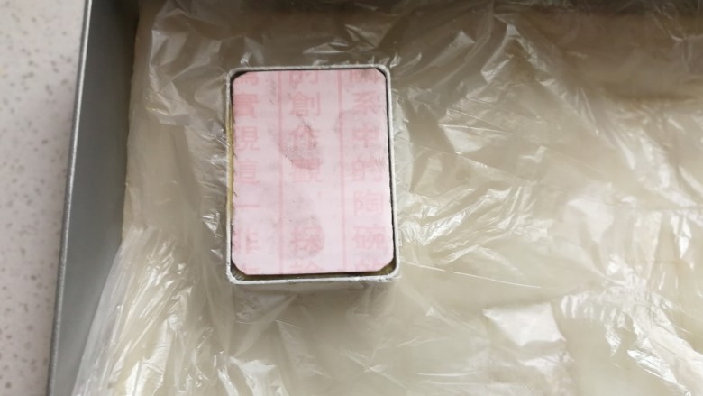 玫瑰凤梨酥,先盖上一小块保鲜膜,再把硬纸卡片放在模具中,双手在四个角稍微用力按压纸片,压好后取下纸片和保鲜膜,一个完美有型的凤梨酥就压好了