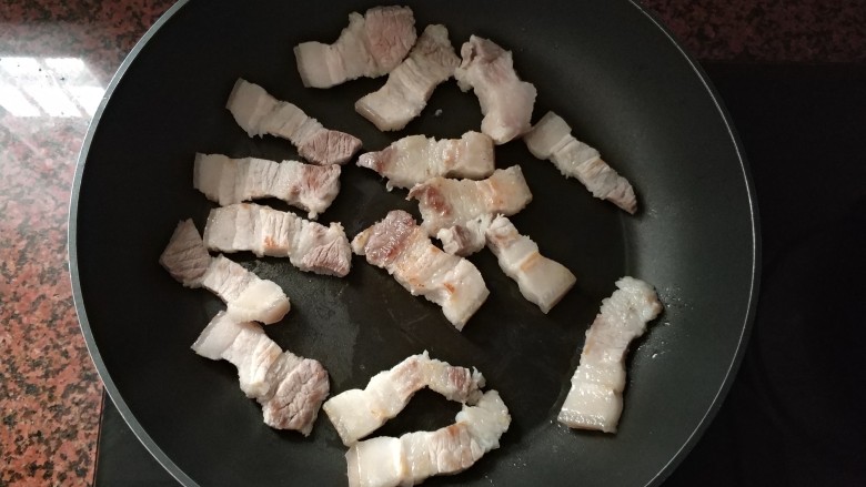 潮汕系列~苦笋煲,平底锅热下,把切好的五花肉,放进去煎至皮变色就可以。