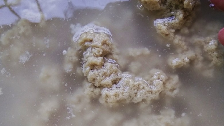 烤面筋,用大盆放入清水,往盆里撒谷元粉,边撒边搅拌