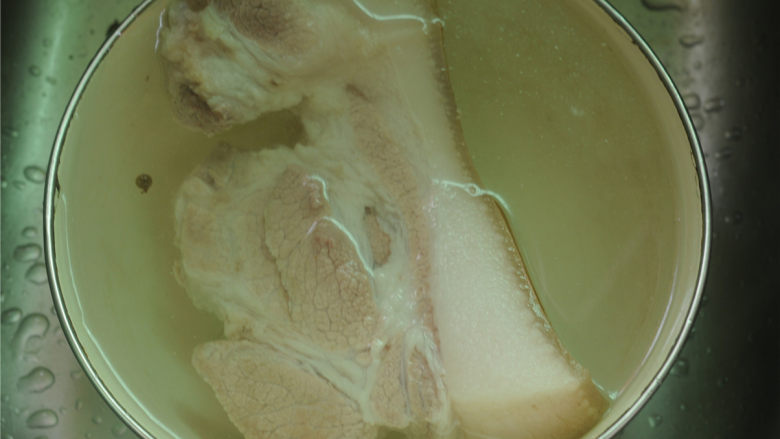 酱烧回锅肉,将浮沫撇去,看到猪肉完全变色后,将其捞出,用凉水紧一下