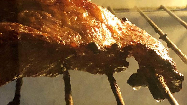炭烧猪颈肉,翻面后继续放烤箱内烤10-12分钟。
猪肉表面的油脂在细细密密地翻滚,发出吱吱的声音,眼见着一滴滴的油往下掉,这因为有此过程,吃起来才不会那么腻啊。