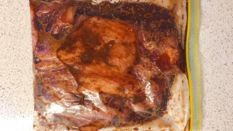 炭烧猪颈肉,把猪颈肉和腌料一起倒入食品密实袋,放入冰箱冷藏过夜。赶时间的话腌制4小时也行。